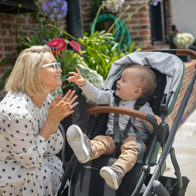 Mom playing and smiling with her baby in the  UPPAbaby VISTA V2 Stroller in -- Color_Gwen