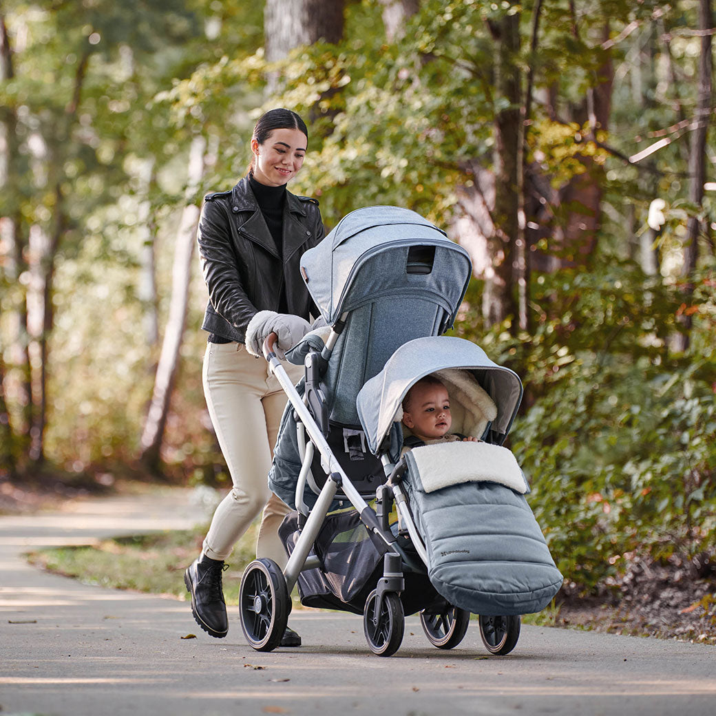 Young mother taking a walk with her two kids in the Vista V2 Double Stroller in -- Color Gregory