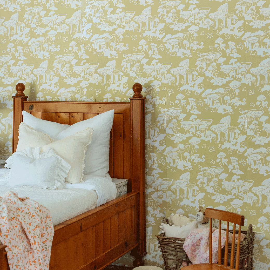 Bed with pillows next to the Anewall Forest Floor Mushroom Wallpaper