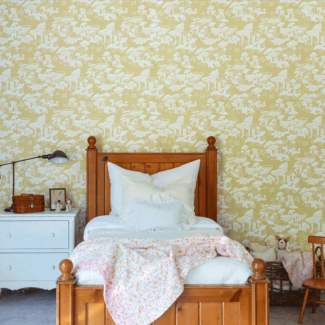 Lifestyle front view of bed in a room furnished with Anewall Forest Floor Mushroom Wallpaper