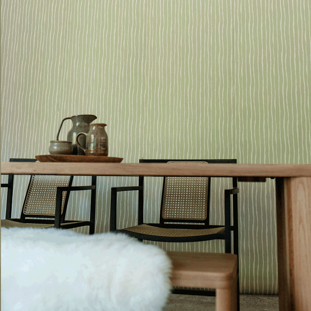 Low angle view of table with chairs in front of Anewall Soft Stripes Wallpaper