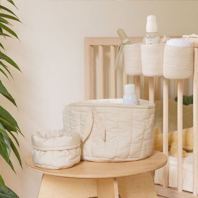 Lorena Canals Bambie Quilted Baskets next to a crib and plant  in -- Color_Natural
