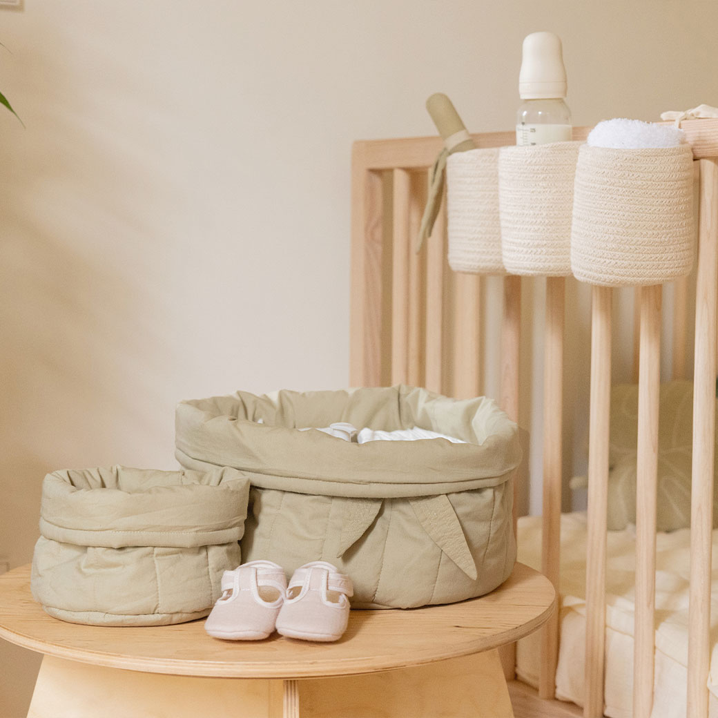 Lorena Canals Bambie Quilted Baskets with supplies next to a crib  in -- Color_Olive