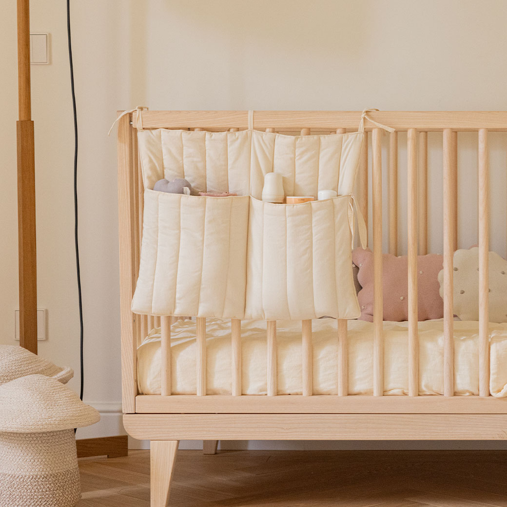 Lifestyle view of Lorena Canals Benjamin Pocket Hanger on a crib  in -- Color_Natural