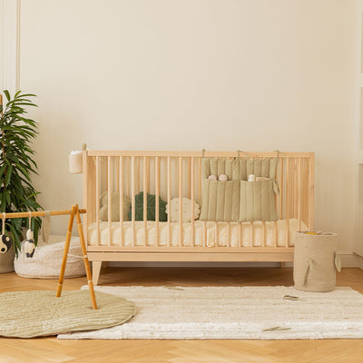 Lifestyle view of a room with Lorena Canals Benjamin Pocket Hanger hanging from a crib in -- Color_Olive