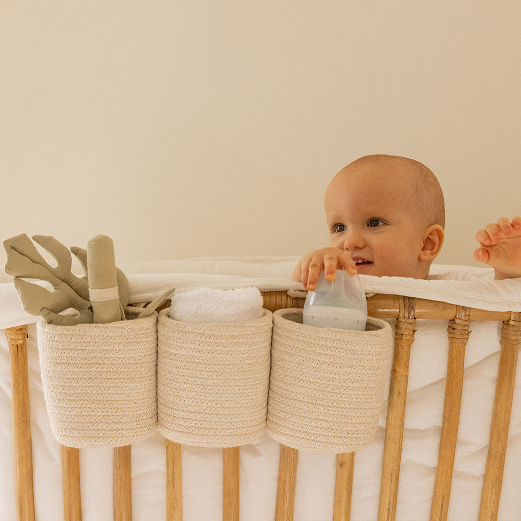 Baby in a crib with Lorena Canals Bobby Crib Basket in -- Color_Vanilla