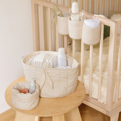 The Lorena Canals Bobby Crib Basket on a crib next to basket set in -- Color_Vanilla