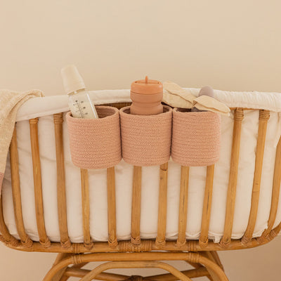 Lifestyle view of Lorena Canals Bobby Crib Basket hanging from a crib rail  in -- Color_Vintage Nude