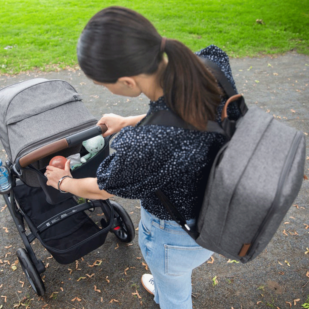 Mommy carrying the UPPAbaby Changing Backpack on her back in -- Color_Gregory