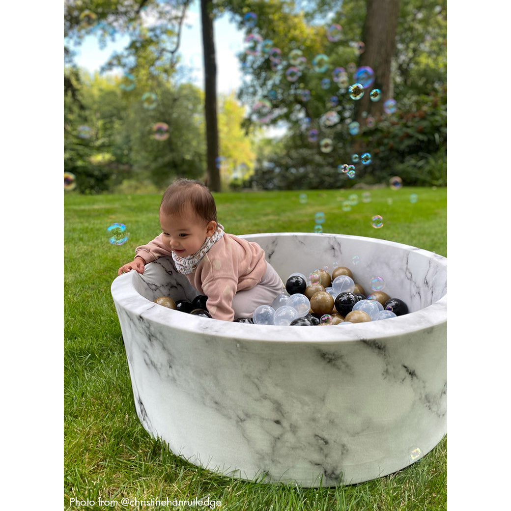 Baby climbing out of marble ball pit -- Lifestyle