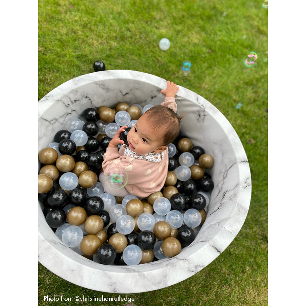 Baby in marble ball pit- view from above -- Lifestyle