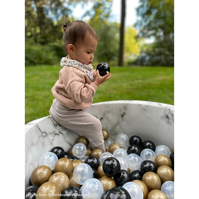 Baby climbing into marble ball pit -- Lifestyle