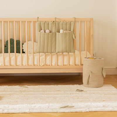 Lorena Canals Bamboo Forest Washable Rug next to a crib and basket 