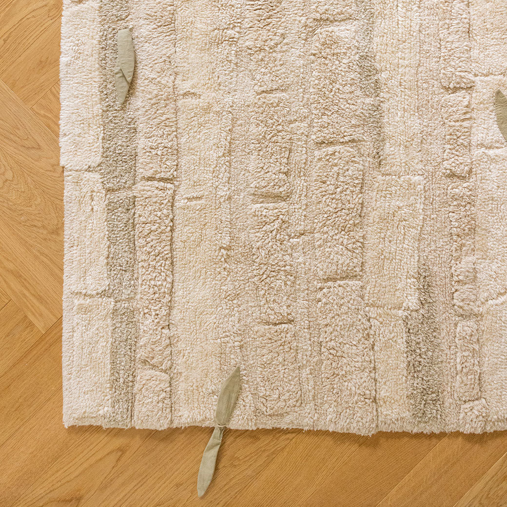 Corner view of Lorena Canals Bamboo Forest Washable Rug with a leaf detail 