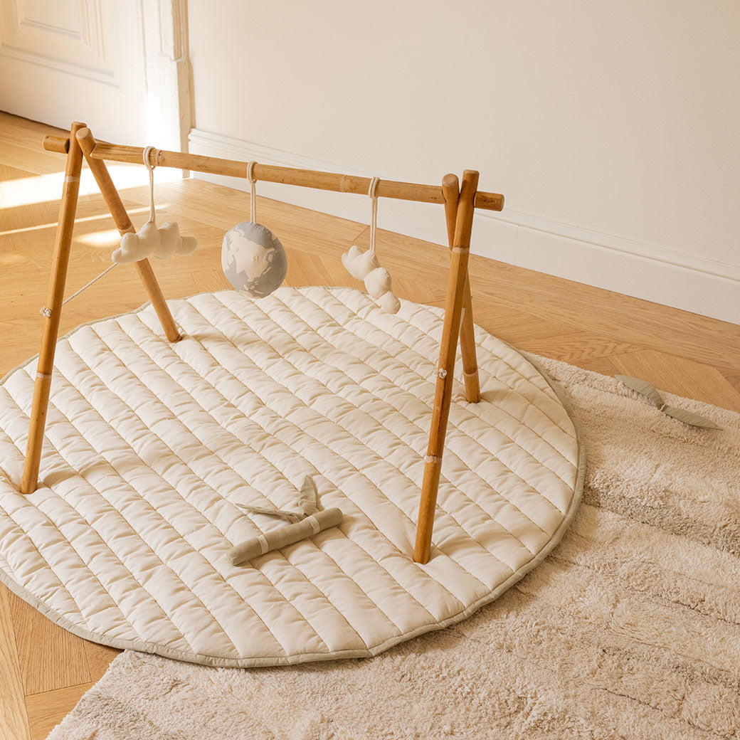 The Lorena Canals Products Bamboo Leaf Playmat on a rug