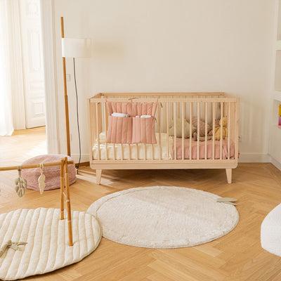 Lorena Canals Bamboo Leaf Washable Rug in a child`s room next to a crib and playmat 