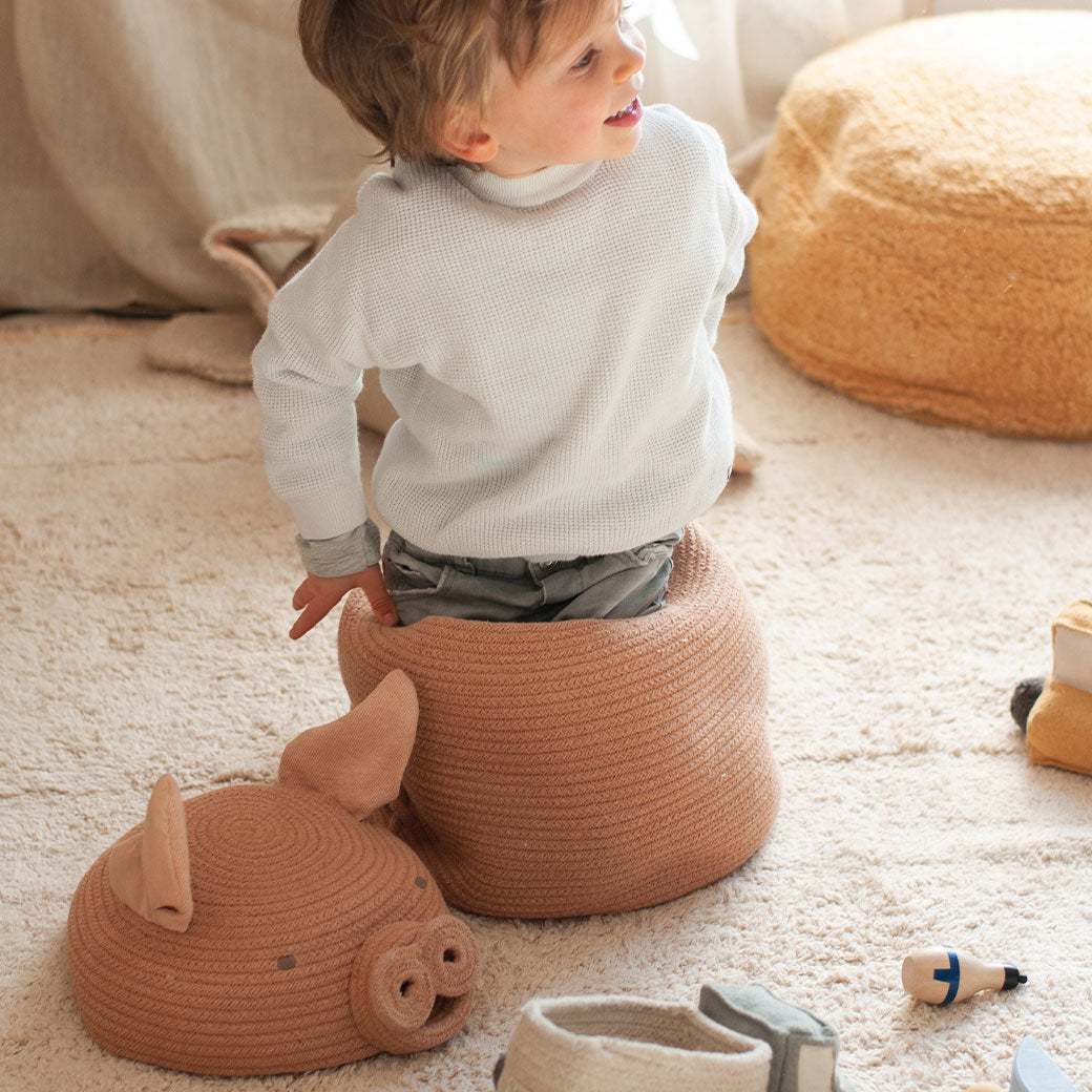 A child playing inside the Lorena Canals Peggy the Pig Basket