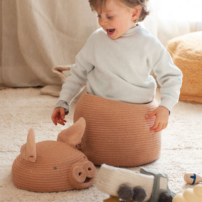A child smiling and playing with the Lorena Canals Peggy the Pig Basket