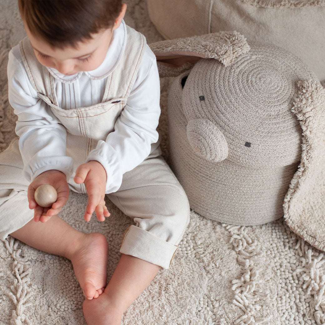 A child sitting next to the Lorena Canals Rita the Rabbit Basket
