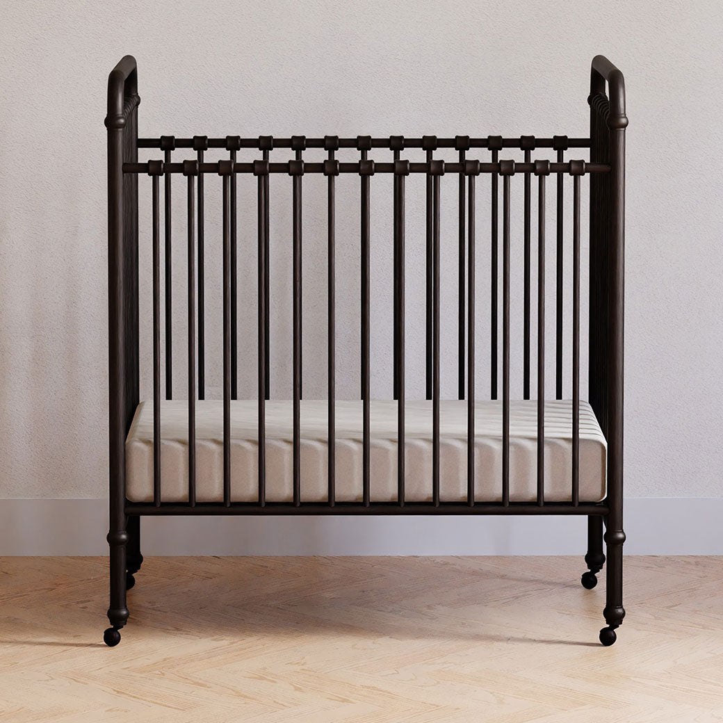 Front view of Namesake`s Abigail 3-in-1 Convertible Mini Crib in a room in -- Color_Vintage Iron