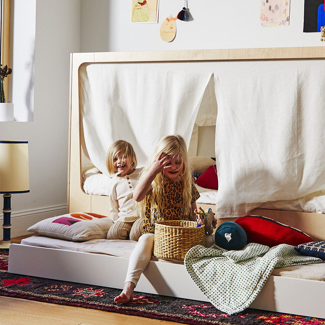 Lifestyle view of Oeuf Perch Nest Bed with two children playing on the lower mattress 