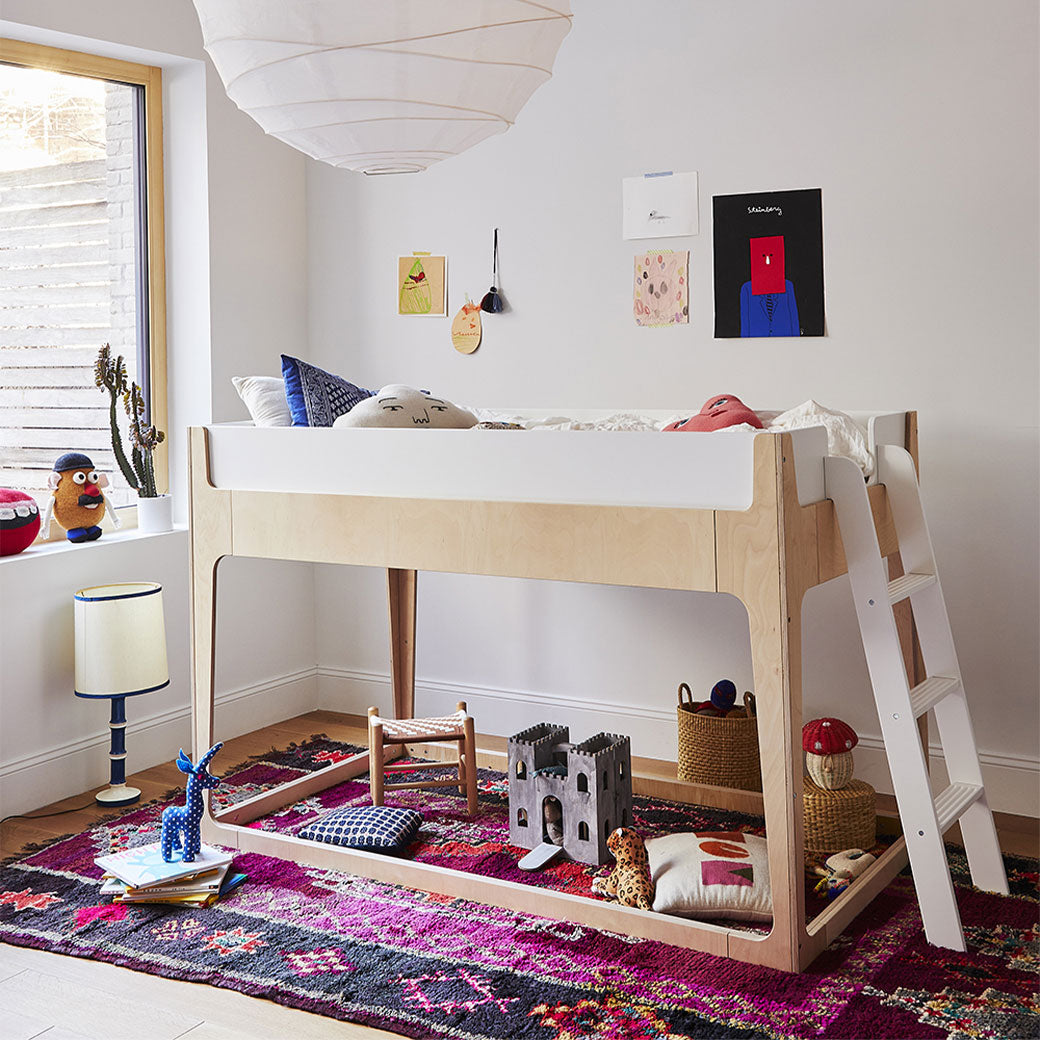 Lifestyle view of Oeuf Perch Nest Bed with mattress above and toys bellow it