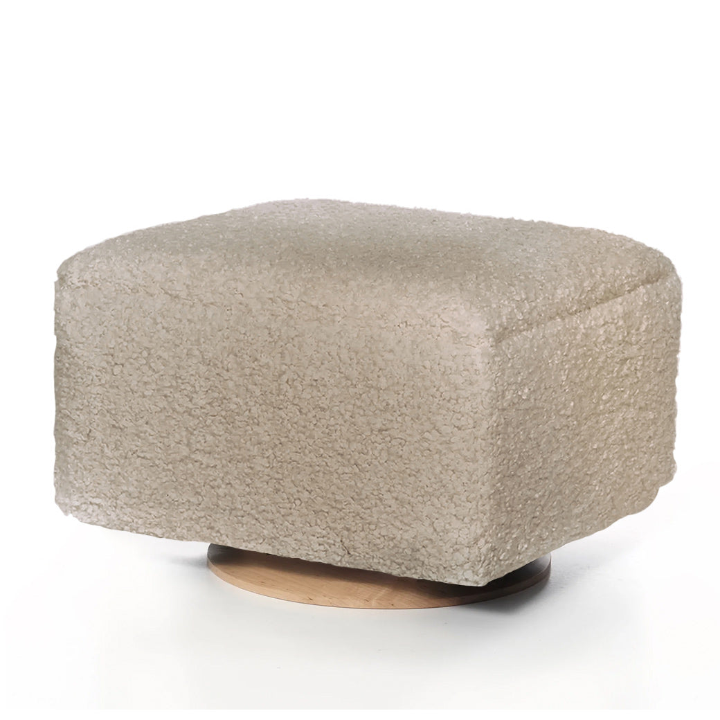 Light beige ottoman with soft textured fabric and rounded corners.