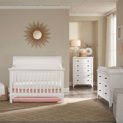 Westwood Design Taylor Convertible Crib in a room next to dresser  in -- Color_Sea Shell