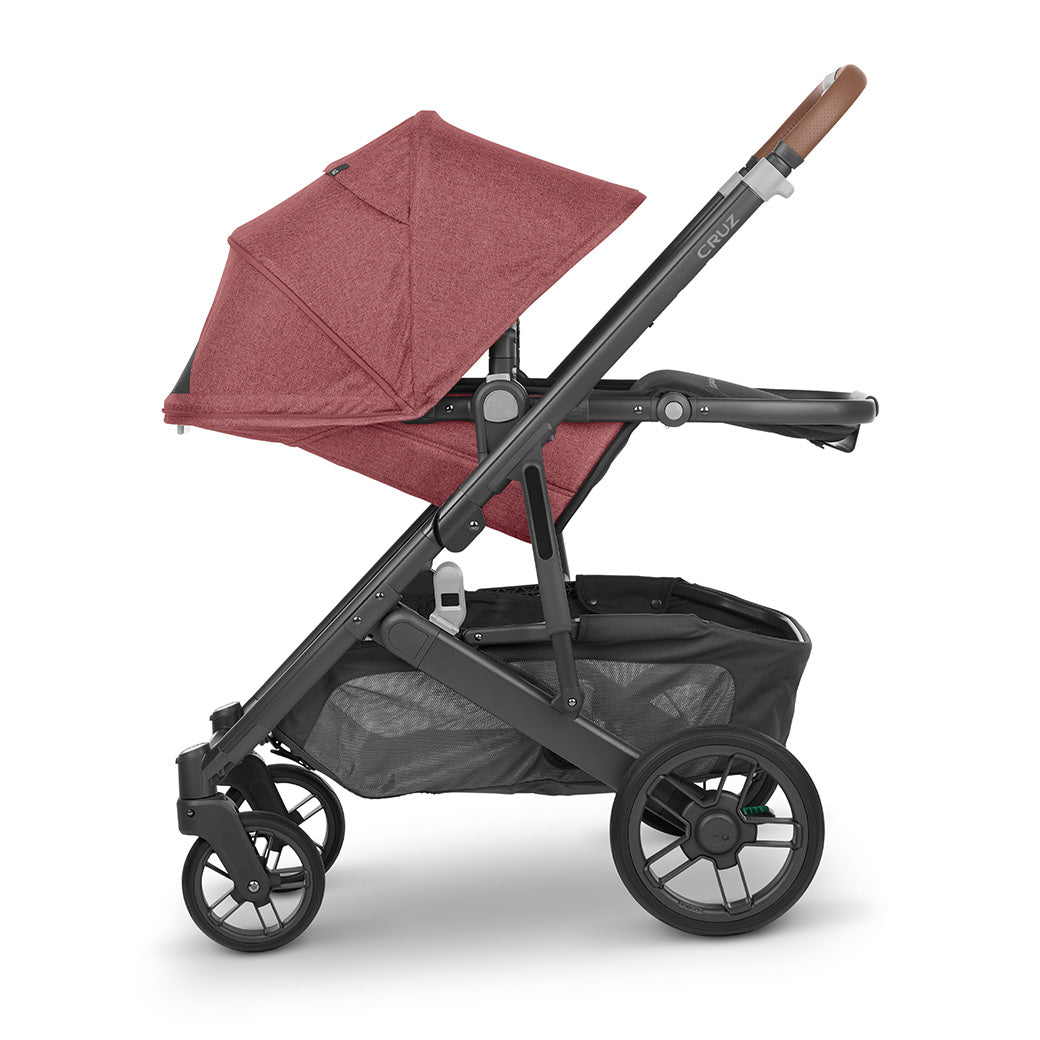 Laying down configuration of UPPAbaby CRUZ V2 Stroller with the shade down in light red -- Color_Lucy