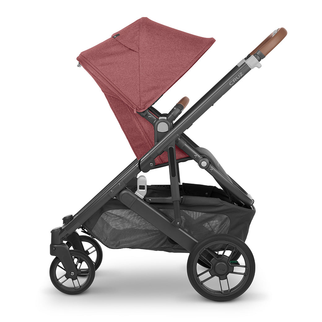 Side view of UPPAbaby CRUZ V2 Stroller with both baskets facing right in light red -- Color_Gwen