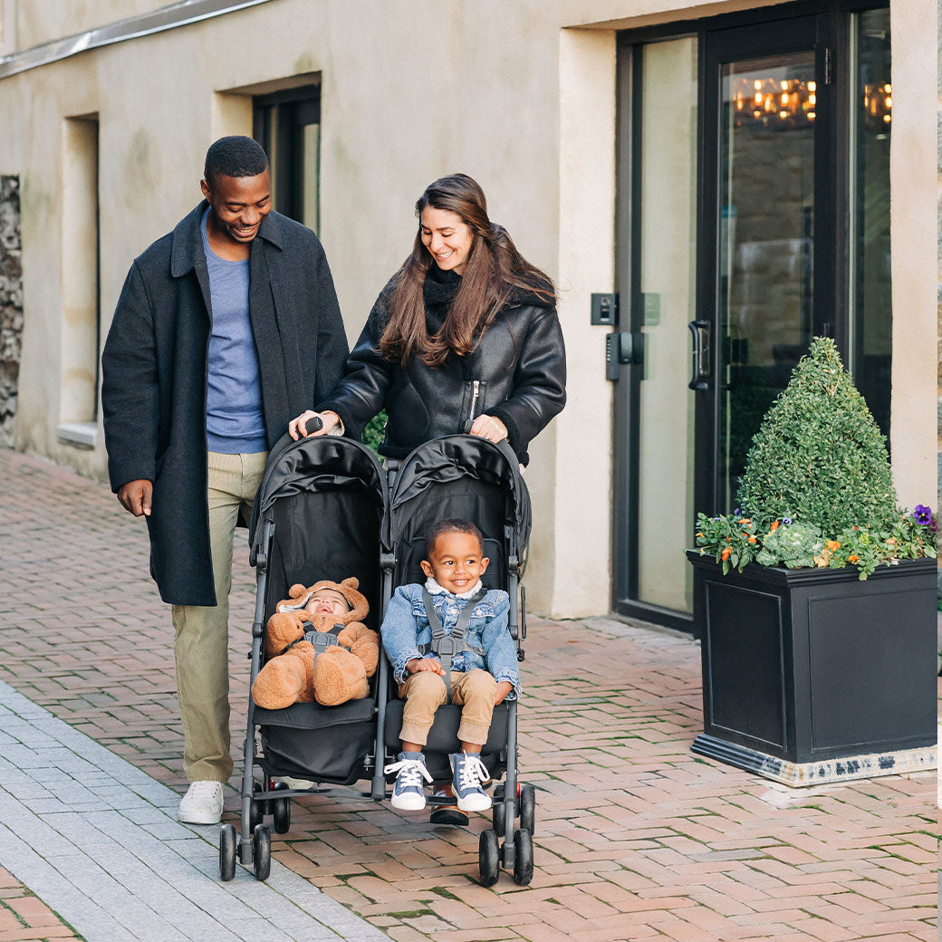 Mother and father on a walk with their kids in the UPPAbaby G Link V2 Stroller in --Color_Jake