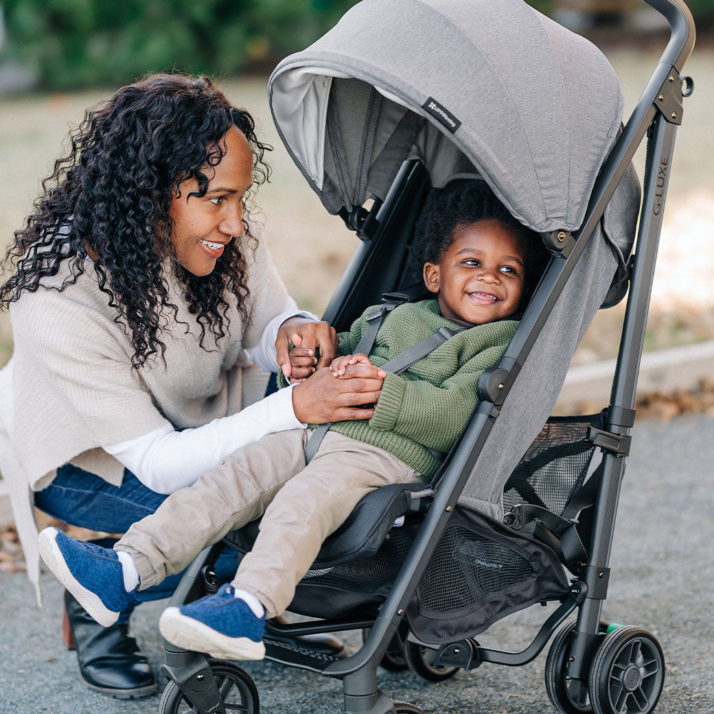 Mother looking at child in the UPPAbaby G-Luxe Stroller  in --Color_Greyson