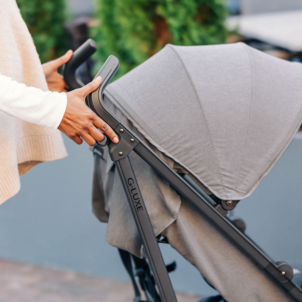 Lifestyle closeup of UPPAbaby G-Luxe Stroller handles in --Color_Greyson