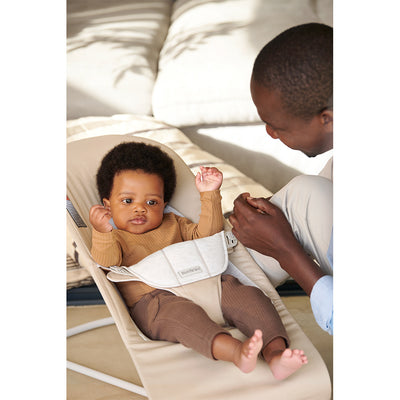 Baby in BABYBJÖRN Bouncer Balance Soft with dad sitting next to baby  in -- Color_Beige/Gray Woven/Jersey