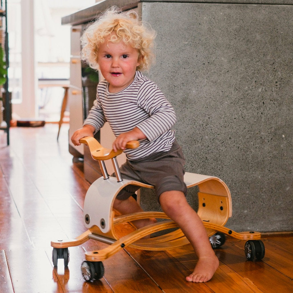 Curly haired child racing around on the wishbone flip in  -- Color_White